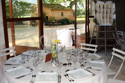 Colonne en pierre sur un socle dans un parc arboré, entourée de pelouse et d'arbres feuillus.