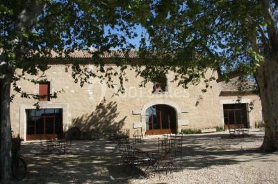 Colonne en pierre sur un socle dans un parc arboré, entourée de pelouse et d'arbres feuillus.