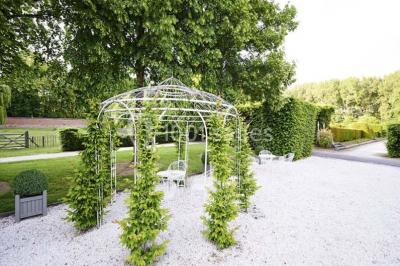 Cour pavée éclairée par des bougies et lumières chaudes, avec un bâtiment historique en arrière-plan, de nuit.