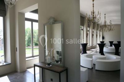 Cour pavée éclairée par des bougies et lumières chaudes, avec un bâtiment historique en arrière-plan, de nuit.