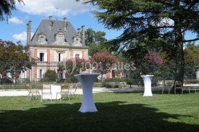 Parking devant un bâtiment en pierre marqué ’Château Saint Ahon’, entouré d'arbres et sous un ciel dégagé.