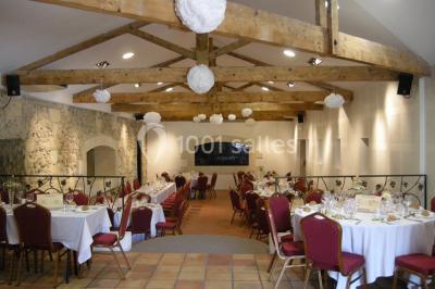 Parking devant un bâtiment en pierre marqué ’Château Saint Ahon’, entouré d'arbres et sous un ciel dégagé.