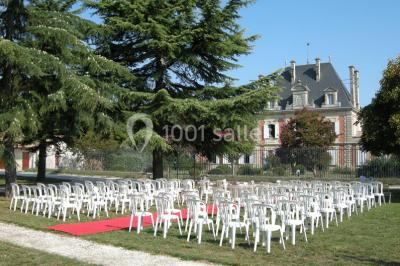 Parking devant un bâtiment en pierre marqué ’Château Saint Ahon’, entouré d'arbres et sous un ciel dégagé.
