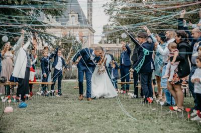 Parking devant un bâtiment en pierre marqué ’Château Saint Ahon’, entouré d'arbres et sous un ciel dégagé.