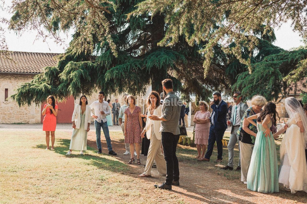 Un groupe de personnes se tient debout dans un jardin, près d'arbres, lors d'un événement en plein air.
