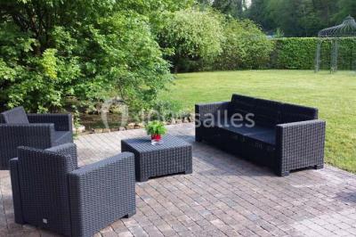 Roses roses et blanches en gros plan devant une pelouse et des arbres verdoyants sous un ciel clair.