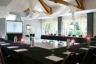 Roses roses et blanches en gros plan devant une pelouse et des arbres verdoyants sous un ciel clair.