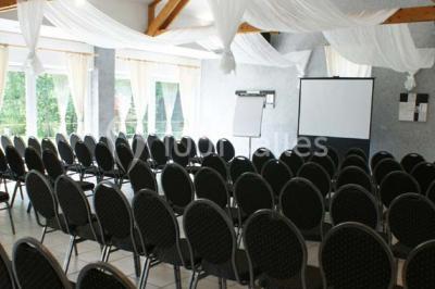 Roses roses et blanches en gros plan devant une pelouse et des arbres verdoyants sous un ciel clair.