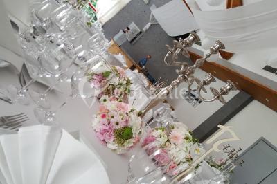 Roses roses et blanches en gros plan devant une pelouse et des arbres verdoyants sous un ciel clair.