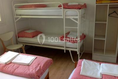 Une chambre d'enfant avec un lit bébé, une table à langer, une chaise haute et des cadres accrochés au mur.