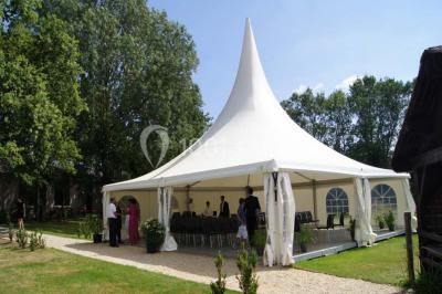 Une chambre d'enfant avec un lit bébé, une table à langer, une chaise haute et des cadres accrochés au mur.