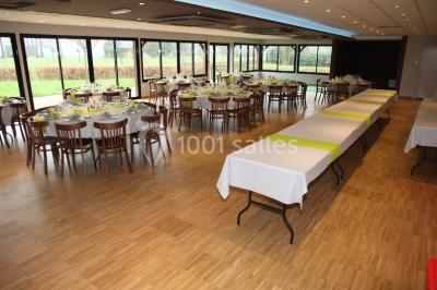 Bâtiment illuminé de nuit avec des façades vitrées et un toit en pente, entouré d'obscurité.