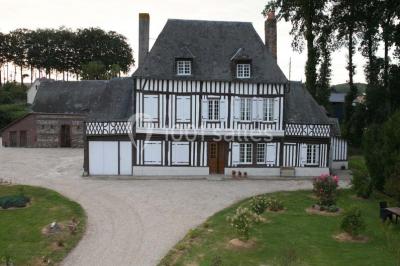 Bâtiment illuminé de nuit avec des façades vitrées et un toit en pente, entouré d'obscurité.