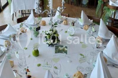 Bâtiment illuminé de nuit avec des façades vitrées et un toit en pente, entouré d'obscurité.