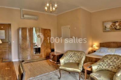 Canal bordé d'arbres avec une écluse centrale et un paysage verdoyant sous un ciel partiellement nuageux.