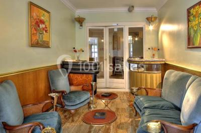 Canal bordé d'arbres avec une écluse centrale et un paysage verdoyant sous un ciel partiellement nuageux.