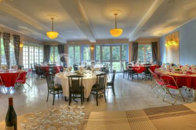 Canal bordé d'arbres avec une écluse centrale et un paysage verdoyant sous un ciel partiellement nuageux.