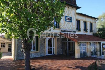 Canal bordé d'arbres avec une écluse centrale et un paysage verdoyant sous un ciel partiellement nuageux.