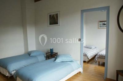 Arche de cérémonie décorée de fleurs blanches et de voilages verts, installée dans un jardin ombragé.