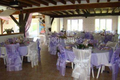 Arche de cérémonie décorée de fleurs blanches et de voilages verts, installée dans un jardin ombragé.