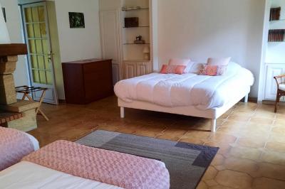 Arche de cérémonie décorée de fleurs blanches et de voilages verts, installée dans un jardin ombragé.