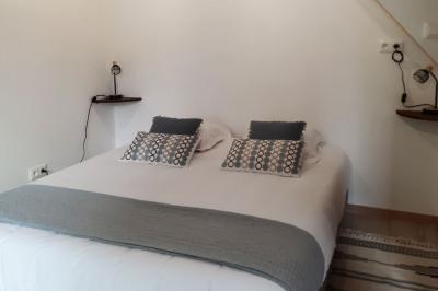 Arche de cérémonie décorée de fleurs blanches et de voilages verts, installée dans un jardin ombragé.