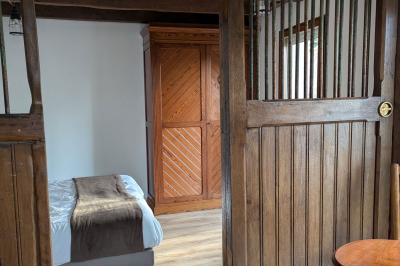 Arche de cérémonie décorée de fleurs blanches et de voilages verts, installée dans un jardin ombragé.