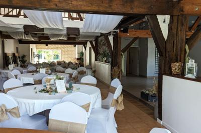 Arche de cérémonie décorée de fleurs blanches et de voilages verts, installée dans un jardin ombragé.