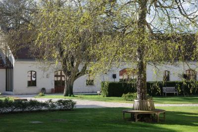 Cour enneigée avec bâtiments en pierre, un pigeonnier cylindrique et des arbres nus sous un ciel dégagé.