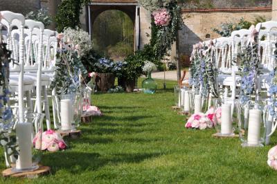 Cour enneigée avec bâtiments en pierre, un pigeonnier cylindrique et des arbres nus sous un ciel dégagé.