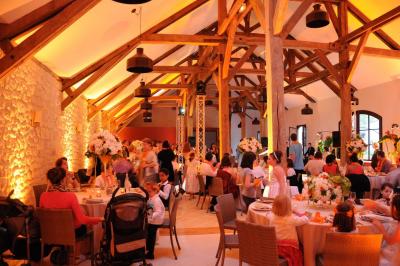 Cour enneigée avec bâtiments en pierre, un pigeonnier cylindrique et des arbres nus sous un ciel dégagé.