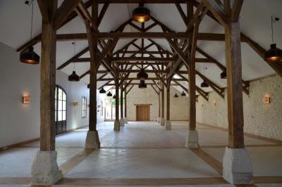 Cour enneigée avec bâtiments en pierre, un pigeonnier cylindrique et des arbres nus sous un ciel dégagé.