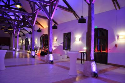 Cour enneigée avec bâtiments en pierre, un pigeonnier cylindrique et des arbres nus sous un ciel dégagé.