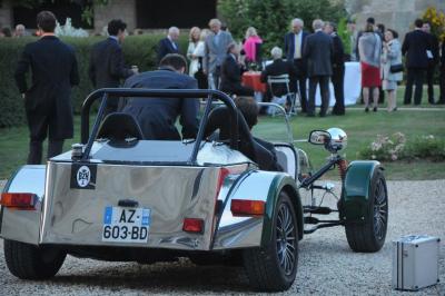 Cour enneigée avec bâtiments en pierre, un pigeonnier cylindrique et des arbres nus sous un ciel dégagé.