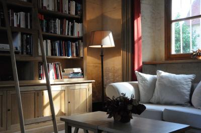 Cour enneigée avec bâtiments en pierre, un pigeonnier cylindrique et des arbres nus sous un ciel dégagé.