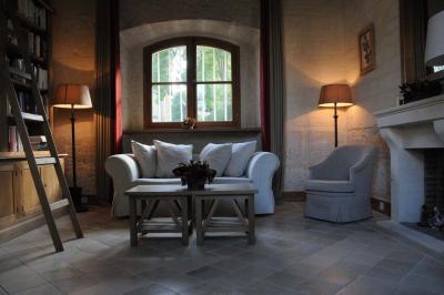 Cour enneigée avec bâtiments en pierre, un pigeonnier cylindrique et des arbres nus sous un ciel dégagé.