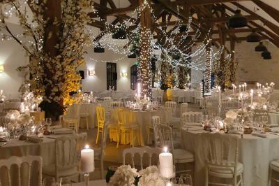 Cour enneigée avec bâtiments en pierre, un pigeonnier cylindrique et des arbres nus sous un ciel dégagé.