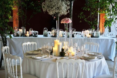 Cour enneigée avec bâtiments en pierre, un pigeonnier cylindrique et des arbres nus sous un ciel dégagé.