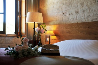 Cour enneigée avec bâtiments en pierre, un pigeonnier cylindrique et des arbres nus sous un ciel dégagé.