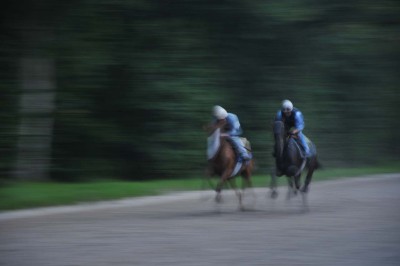 Cour enneigée avec bâtiments en pierre, un pigeonnier cylindrique et des arbres nus sous un ciel dégagé.