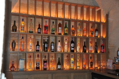 Cour enneigée avec bâtiments en pierre, un pigeonnier cylindrique et des arbres nus sous un ciel dégagé.