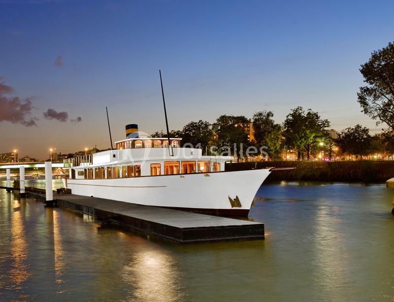 Location salle Paris 15 (Paris) - Paris Yacht Marina #9 Bateau blanc amarré à un quai au crépuscule, entouré d'arbres et d'eau calme.