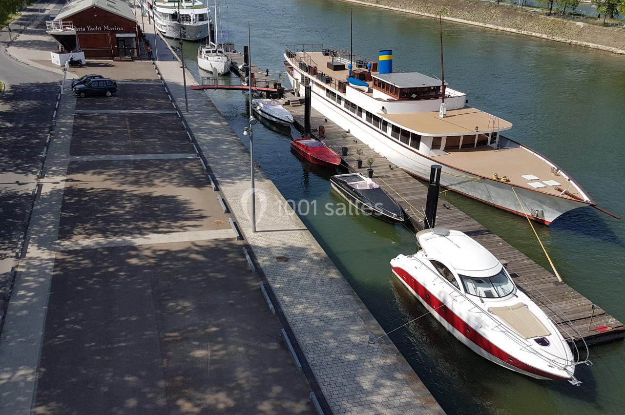 Location salle Paris 15 (Paris) - Paris Yacht Marina #39 Bateaux amarrés le long d'un quai sur une rivière, avec une promenade bordée d'arbres à gauche.