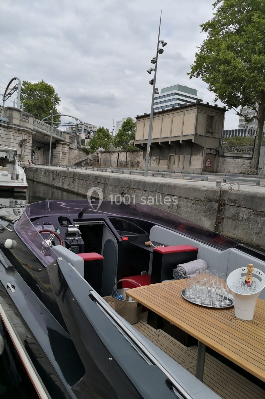 Location salle Paris 15 (Paris) - Paris Yacht Marina #35 Bateau amarré le long d'un quai, avec une table dressée et des bâtiments en arrière-plan.