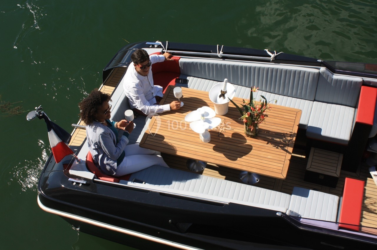 Location salle Paris 15 (Paris) - Paris Yacht Marina #12 Deux personnes assises autour d'une table en bois sur un bateau, partageant un moment convivial sur l'eau.