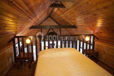 Chambre lumineuse avec un lit double, deux tables de chevet avec lampes allumées et une fenêtre donnant sur un paysage…