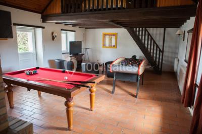 Chambre lumineuse avec un lit double, deux tables de chevet avec lampes allumées et une fenêtre donnant sur un paysage…