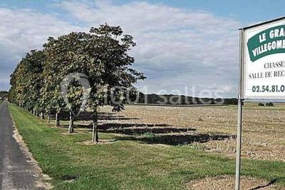 Panneau indiquant ’Le Grand Villeboublain’ près d'une route bordée d'arbres dans un paysage rural.