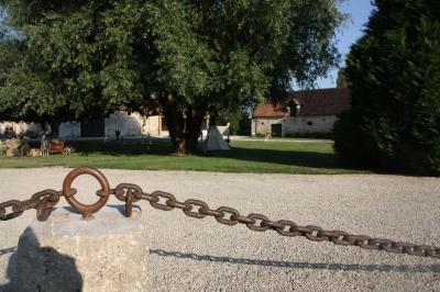 Panneau indiquant ’Le Grand Villeboublain’ près d'une route bordée d'arbres dans un paysage rural.