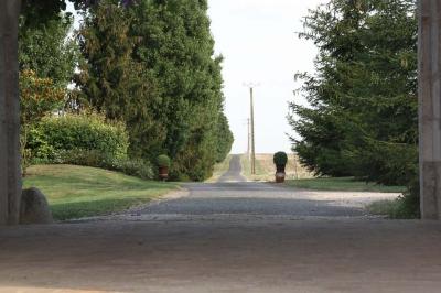 Panneau indiquant ’Le Grand Villeboublain’ près d'une route bordée d'arbres dans un paysage rural.